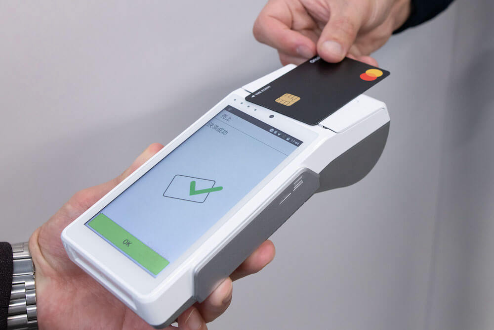 アルファポータブルでクレジットカードのタッチ決済をしている様子