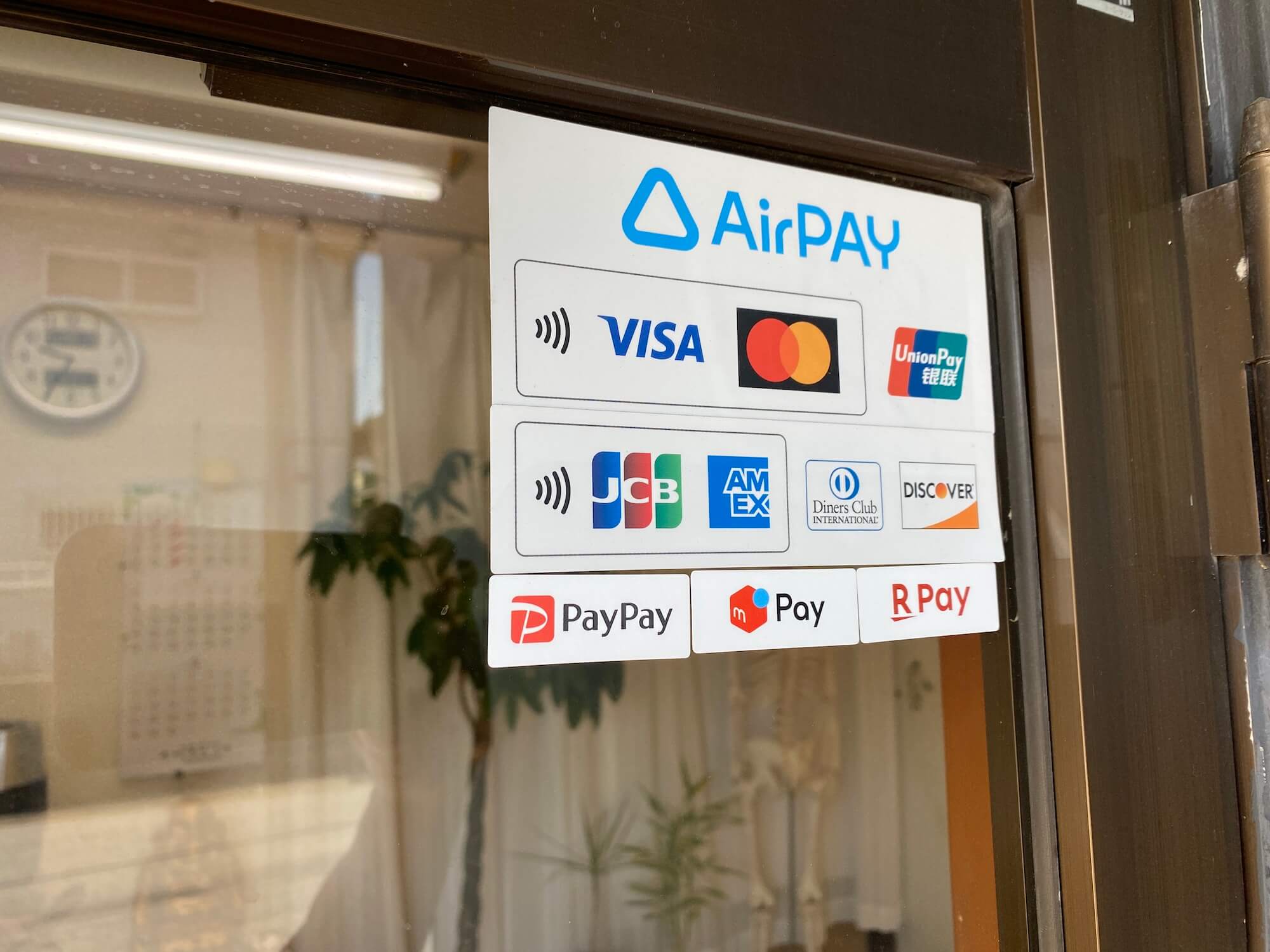 店舗入り口ドアに貼られたAirペイの加盟店ステッカー
